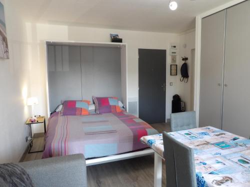 Schlafzimmer mit einem Bett und einem Tisch mit Stühlen in der Unterkunft Appartement T2 à 2 pas de la mer de St Cyprien in Saint-Cyprien