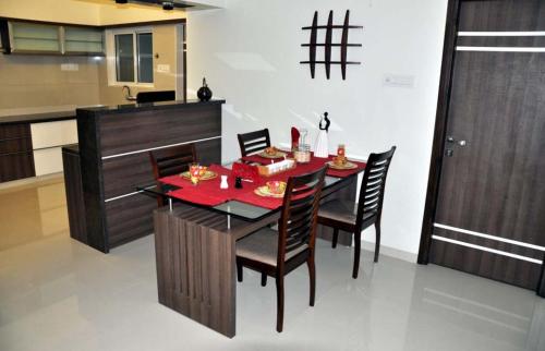 a dining room with a table and chairs in a kitchen at Peaceful Retreat 3BHK For six person in Vadodara
