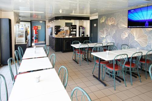 a restaurant with tables and chairs and a counter at Face West Le Pontet in Le Pontet