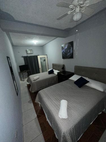 a bedroom with two beds and a ceiling fan at Hospedaje en Juticalpa in Juticalpa