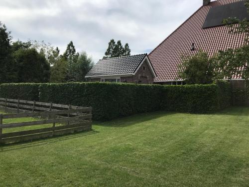 a fence in a yard next to a house at Aldehoeve-logies in Workum
