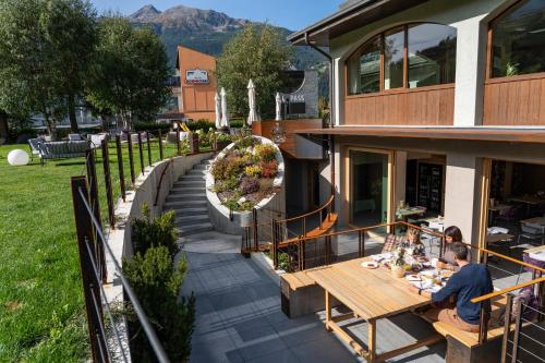 a man sitting at a table outside of a house at Hotel Nevada in Bormio