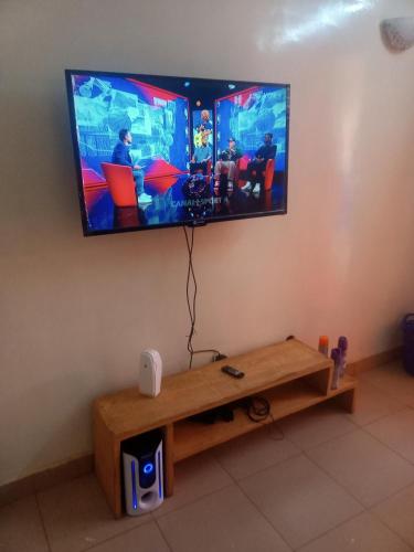 einen Flachbild-TV, der an einer Wand hängt in der Unterkunft Résidence privée in Bobo-Dioulasso