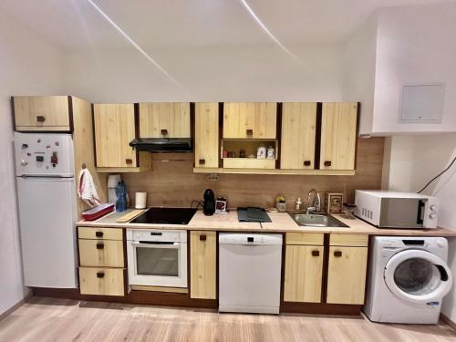 une cuisine avec des armoires en bois et un réfrigérateur blanc dans l'établissement Woody old town appartement by Welcome to Cannes, à Cannes