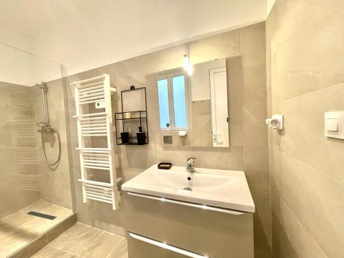 une salle de bain blanche avec un lavabo et une douche dans l'établissement Woody old town appartement by Welcome to Cannes, à Cannes