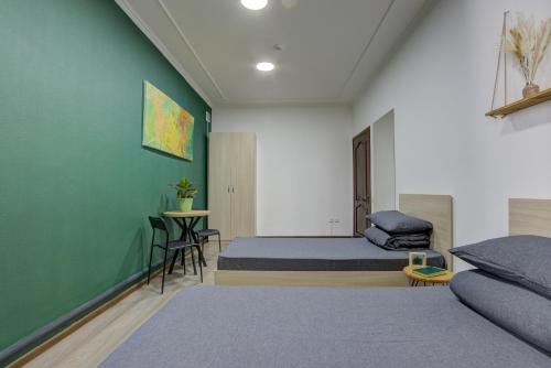a bedroom with two beds and a green wall at People Hostel & Coworking in Bishkek