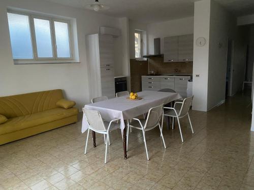 - un salon avec une table, des chaises et un canapé dans l'établissement Isabella's Houses, à Punta Braccetto