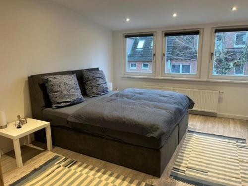 a bedroom with a bed and a table and windows at Ferienwohnung Watzek in Grömitz