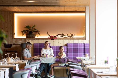 a family sitting at a table in a restaurant at Hotel Nevada in Bormio