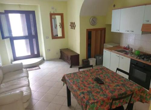een keuken en een woonkamer met een tafel en een bank bij Grazioso Bilocale per scoprire il Molise in relax in San Martino in Pensilis