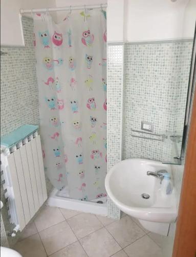 een badkamer met een wastafel en een douchegordijn bij Grazioso Bilocale per scoprire il Molise in relax in San Martino in Pensilis