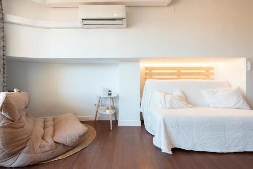 a bedroom with a bed and a chair at Beach & Fun: Cozy Studio in La Pineda