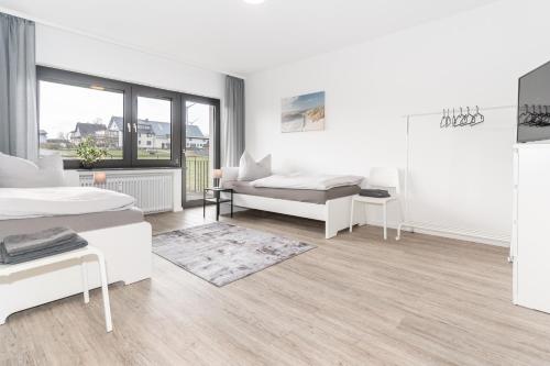 a white room with two beds and a couch at Moderne Ferienwohnung / Monteurswohnung mit 6 Betten in Driedorf/Herborn in Driedorf