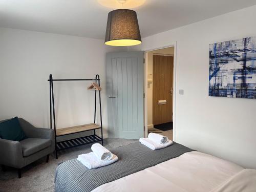 a bedroom with a bed and a chair at All Inn Apartments in Staveley