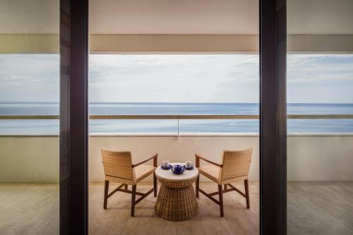a table and chairs in a room with a view of the ocean at Bali Beach Hotel in Sanur