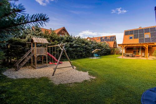 a playground in a yard next to a house at Holiday Raj in Bešeňová