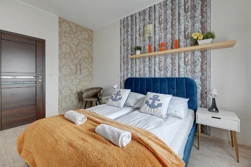 a bedroom with a blue bed with pillows on it at Grand Apartments - Exclusive Beach Apartment in Gdańsk