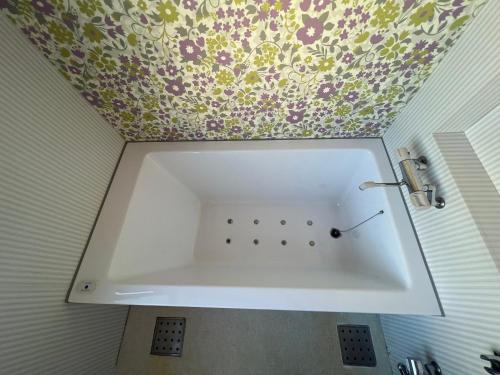 a white sink in a bathroom with a floral ceiling at Hotel FirstWood 成田店 in Narita