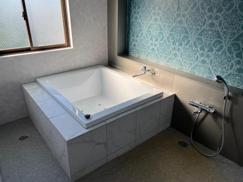 a bath tub in a bathroom with a window at Hotel FirstWood 成田店 in Narita