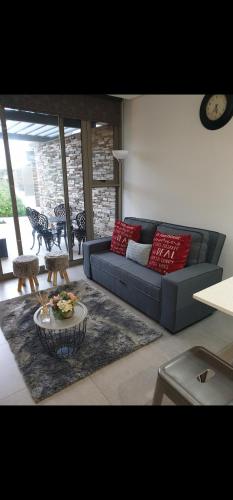 a living room with a blue couch and red pillows at PEBBLE BEACH SIBAYA in Umhlanga