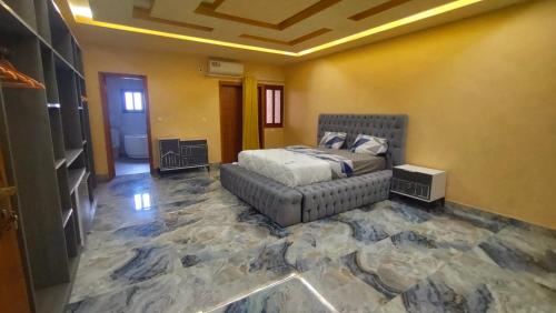 een slaapkamer met een bed en een bank bij Gaïa Luxury Suites in Libreville