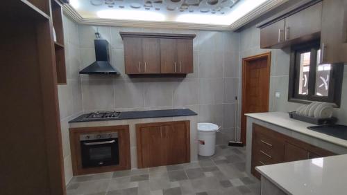 een keuken met houten kasten en een fornuis met oven bij Gaïa Luxury Suites in Libreville