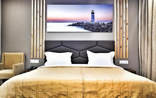 a bedroom with a bed with a lighthouse on the wall at Hotel Delhi Aerocity in New Delhi