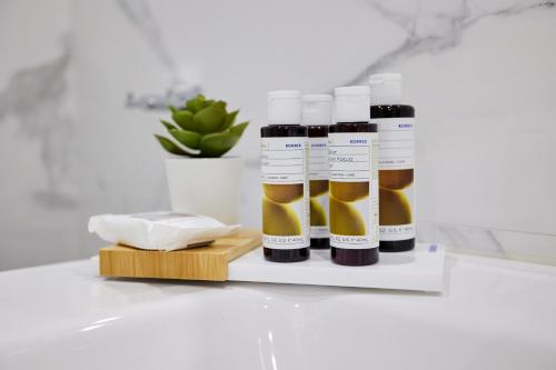 three bottles of oil on a shelf in a bathroom at Vasilicari Apartments in Chios