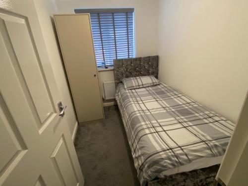 a small bedroom with a bed and a window at Loving Home to Stay with Rear Garden and Patio in Rochdale