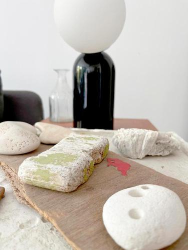 une planche à découper en bois avec du fromage sur une table dans l'établissement Maison Monoï séjour créatif avec activités, spa et services, à Soulac-sur-Mer
