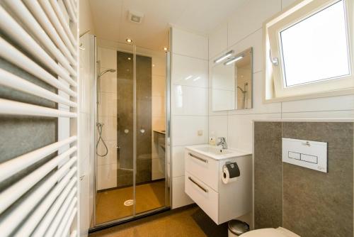 een badkamer met een douche, een toilet en een wastafel bij Camping De Kiekduun in Buren