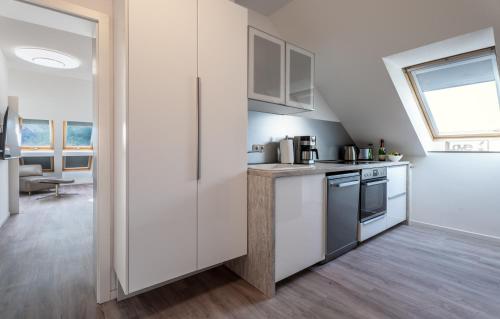 a kitchen with white cabinets and a window at Haus 5 Elemente- Fewo Wasser mit Terrasse und Bio-Kamin in Ostseebad Koserow