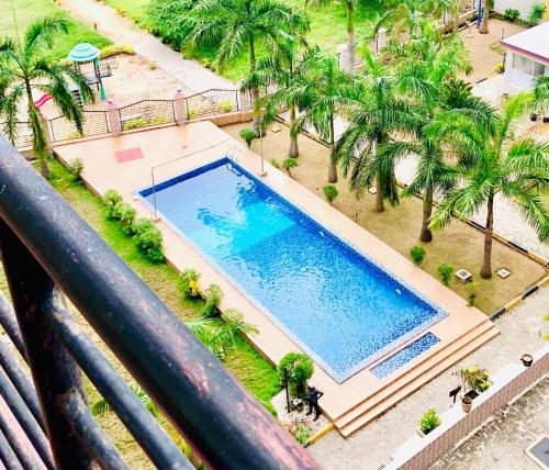 een uitzicht over een zwembad met palmbomen bij Apartment in Dar es salaam , Mikocheni in Dar es Salaam