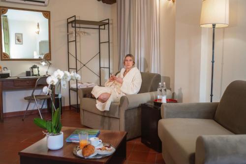 kobieta siedząca na krześle w salonie w obiekcie Dimora Conte Cavour w mieście Vercelli