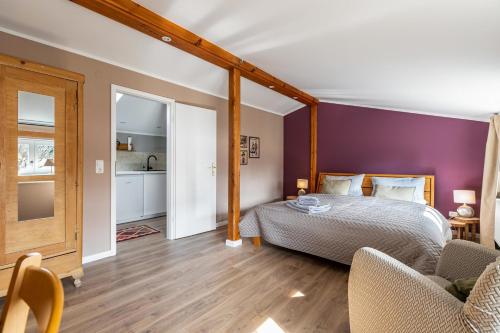 a bedroom with a bed and a purple wall at Ferienwohnung an der Schlei oben in Fleckeby
