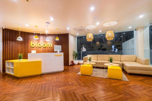 eine Lobby mit einem Sofa und gelben Stühlen in der Unterkunft Bloom Hotel - Ranchi in Ranchi