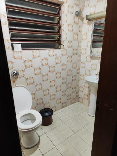 een badkamer met een toilet en een wastafel bij Quarto inferior 10 pessoas. in Caxias do Sul