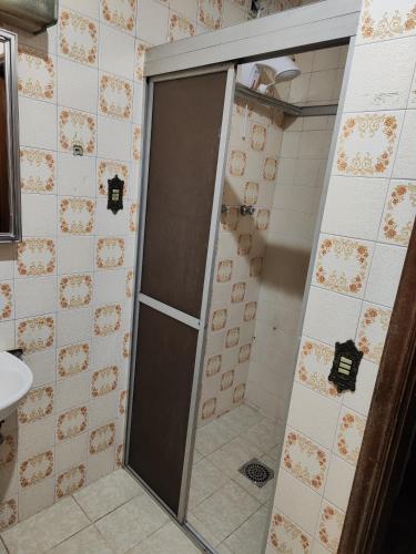 La salle de bains est pourvue d'une douche avec une porte en verre. dans l'établissement Quarto inferior 10 pessoas., à Caxias do Sul