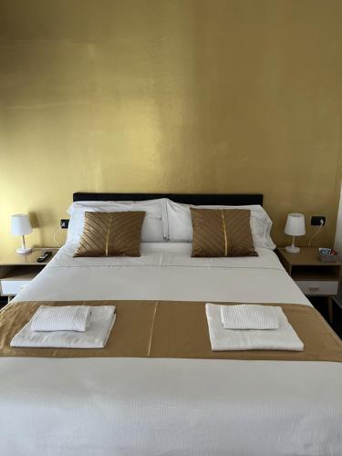 a bedroom with a large bed with two towels on it at Genova Gold Rooms in Genova