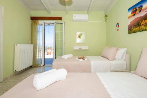 a living room with two beds and a balcony at DM-Discover Margarites Home in Margarítai