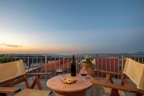 a table with two glasses of wine on a balcony at DM-Discover Margarites Home in Margarítai