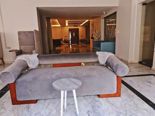 a living room with a couch and a table at Royal Elegance Room in Sheikh Zayed