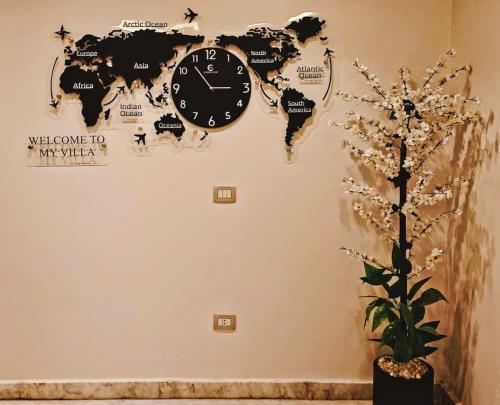 a clock on a wall with a world map at Royal Elegance Room in Sheikh Zayed
