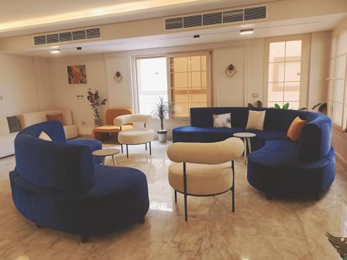 a large living room with blue couches and chairs at Royal Elegance Room in Sheikh Zayed