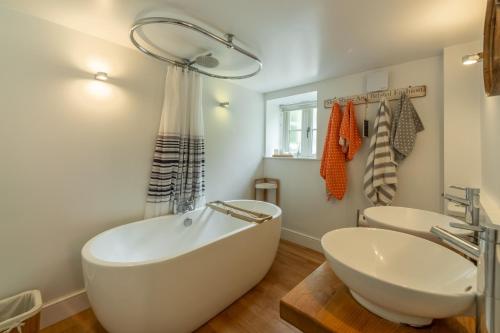 Baño blanco con bañera y lavamanos en The Maltings en Trunch