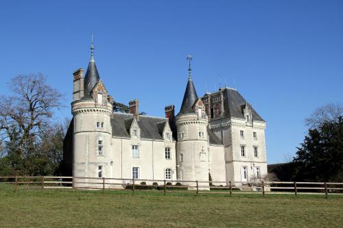 un viejo castillo con una valla delante en Gîte Exotique château de la Pervenchère en Casson