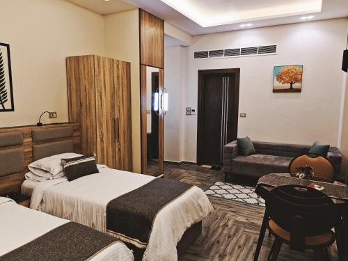a hotel room with two beds and a couch at Royal Elegance Room in Sheikh Zayed