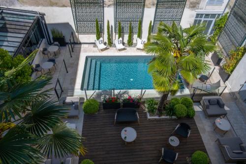 an overhead view of a swimming pool with tables and chairs at Villa Grand Voile - Christopher Coutanceau in La Rochelle