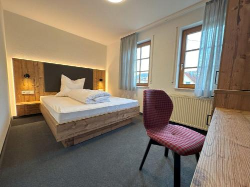 1 dormitorio con 1 cama y 1 silla en Hotel Ochsen en Ammerbuch