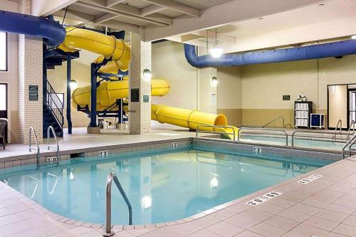 a swimming pool with a slide in a building at Baymont by Wyndham Jamestown Conference Center & Water Park in Jamestown